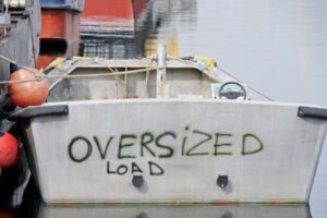 View of a shabby boat with spray painted letters emphazing the need for professional boat lettering design and installation